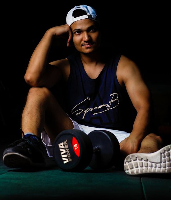 Man in a focused athletic pose against a dark background.